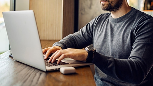 man typing on laptop